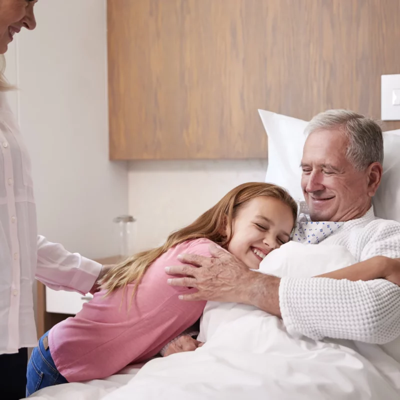 A grandfather and granddaughter together during a hospital visit