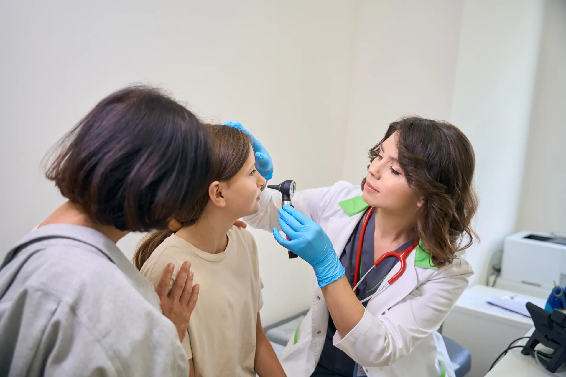 A family doctor using an instrument to examine a patient