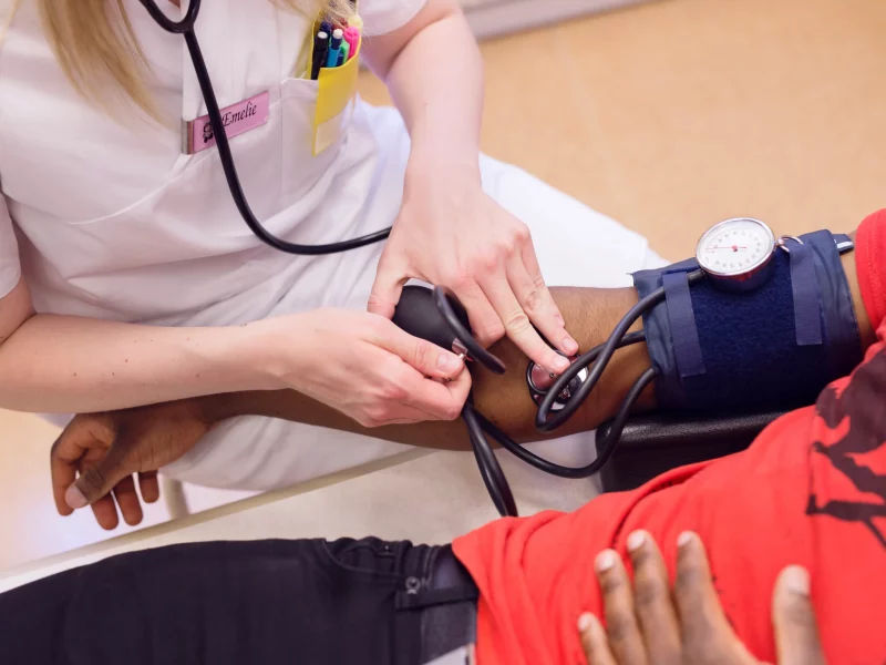 A doctor measuring a young man’s blood pressure